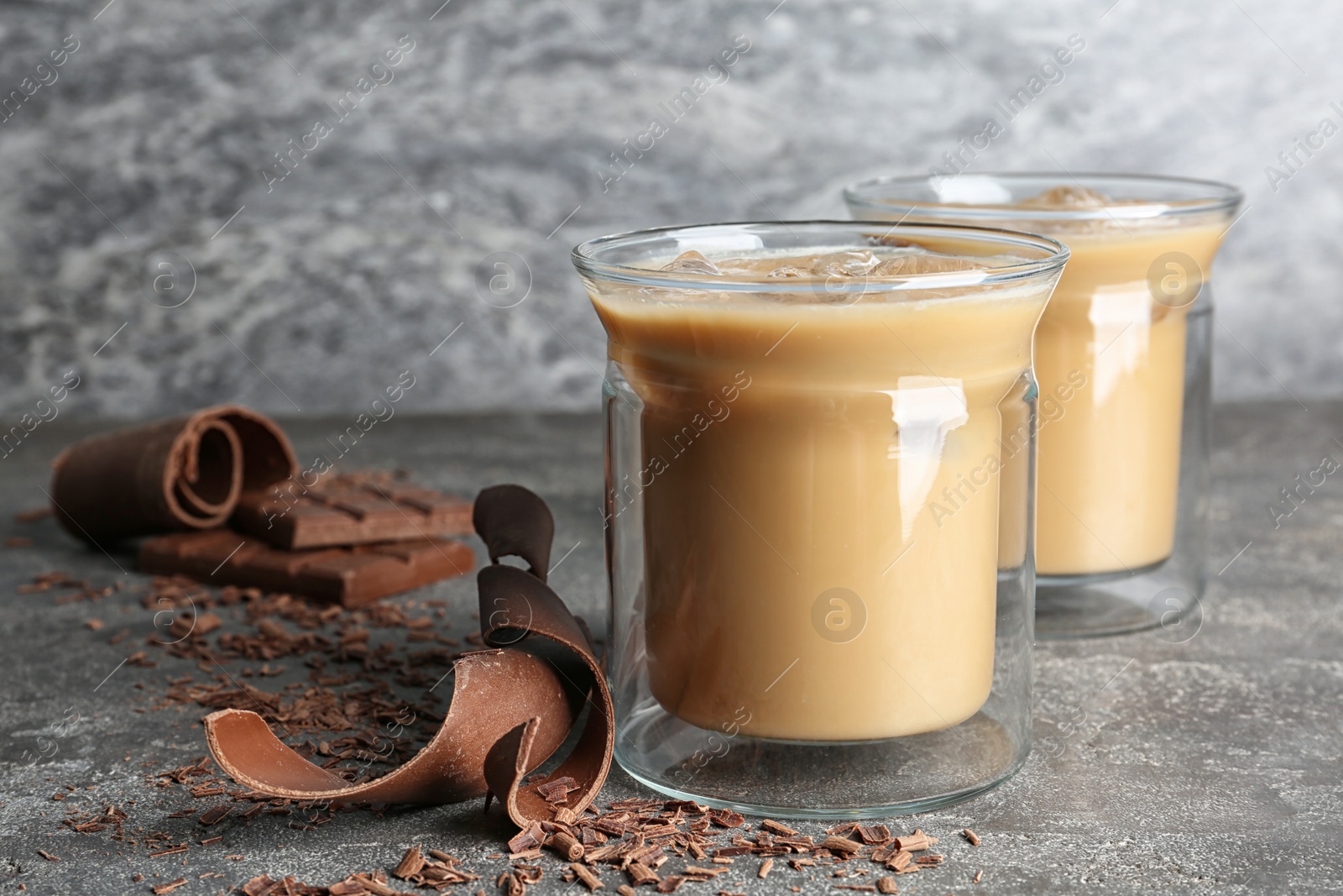 Photo of Glass cups with iced coffee on gray table