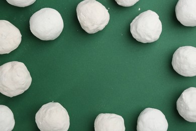Photo of Frame of snowballs on green background, flat lay. Space for text