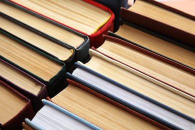 Many different hardcover books as background, closeup