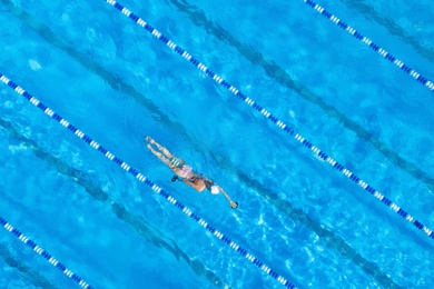 Woman training in swimming pool, top view