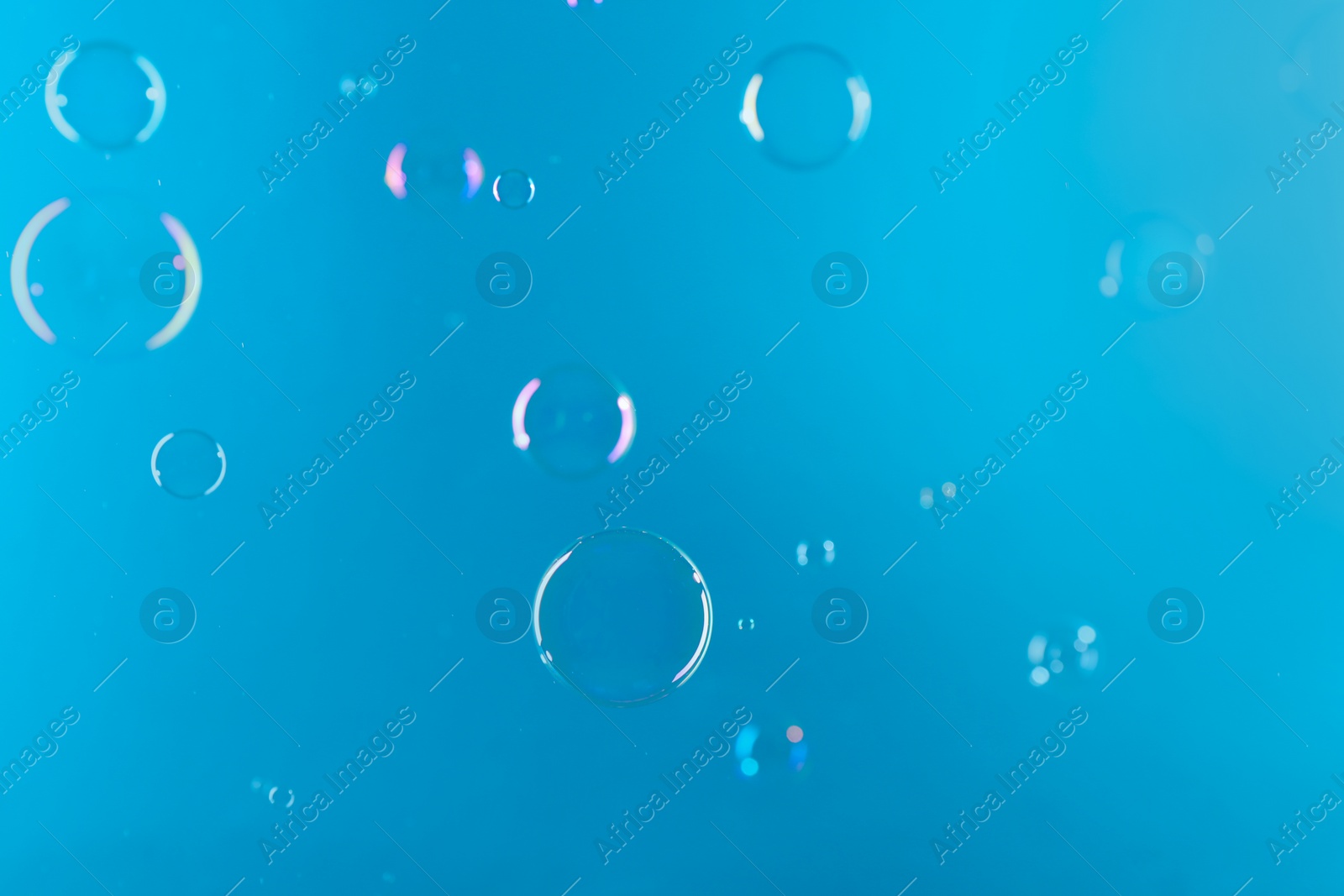 Photo of Beautiful transparent soap bubbles on light blue background