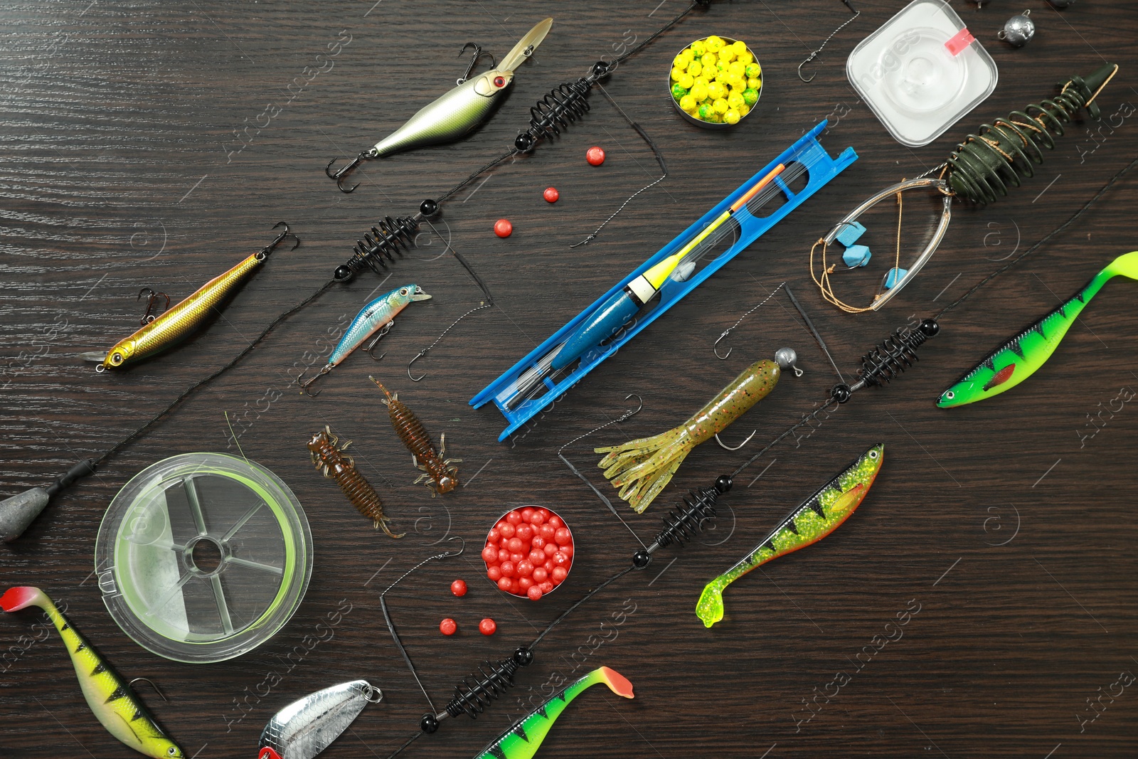 Photo of Fishing tackle on dark wooden background, flat lay