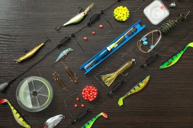 Photo of Fishing tackle on dark wooden background, flat lay