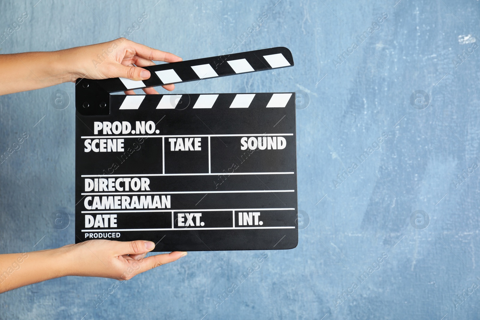 Photo of Woman holding clapperboard against color wall, closeup with space for text. Cinema production