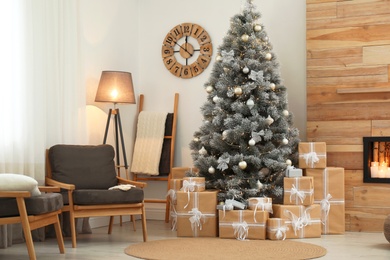 Stylish room interior with beautiful Christmas tree and gift boxes