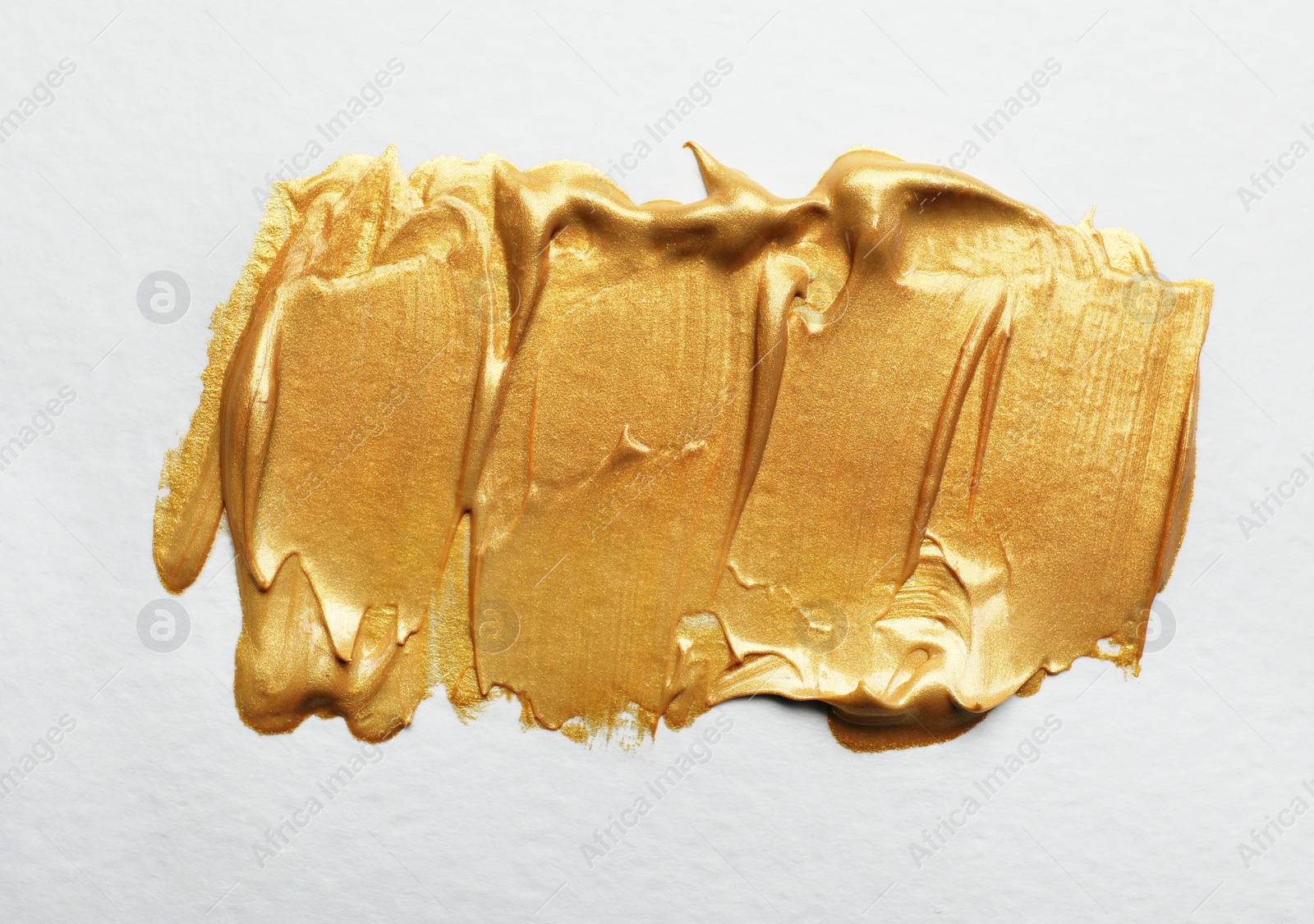 Photo of Golden paint brush strokes on white background