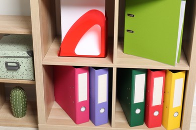 Colorful binder office folders and other stationery on shelving unit