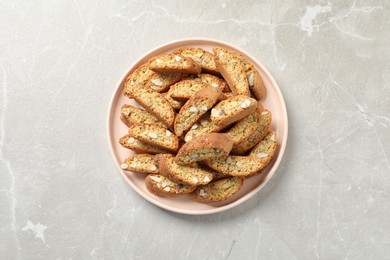 Photo of Traditional Italian almond biscuits (Cantucci) on light marble table, top view