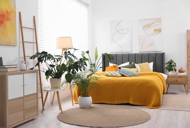 Photo of Bright plaid and colorful pillows on bed in stylish bedroom. Interior design