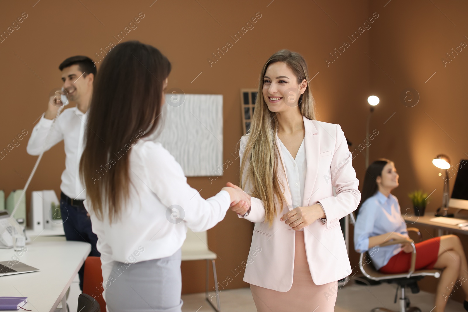 Photo of Human resources manager shaking hands with applicant during job interview in office