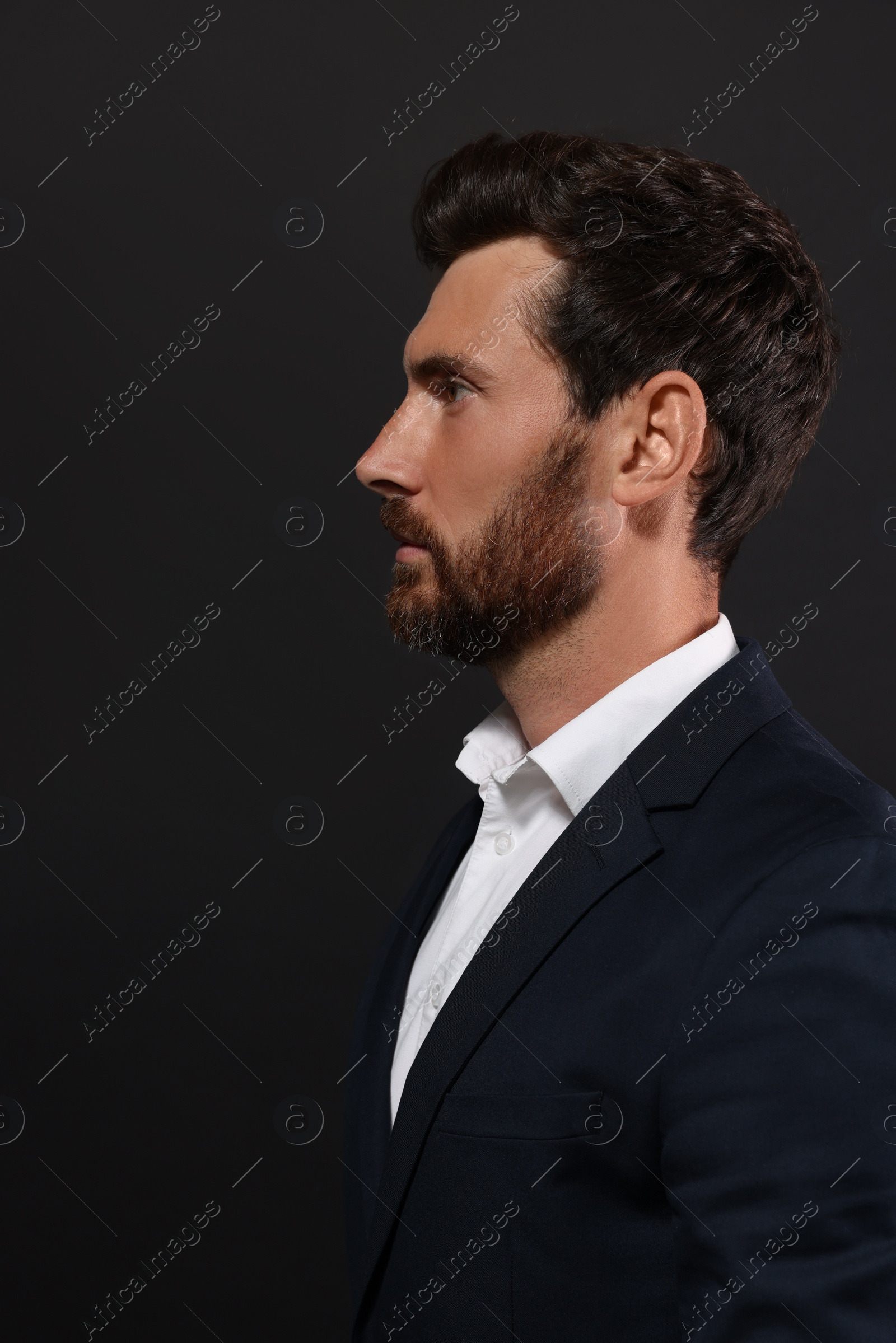 Photo of Profile portrait of handsome bearded man on black background