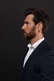 Photo of Profile portrait of handsome bearded man on black background
