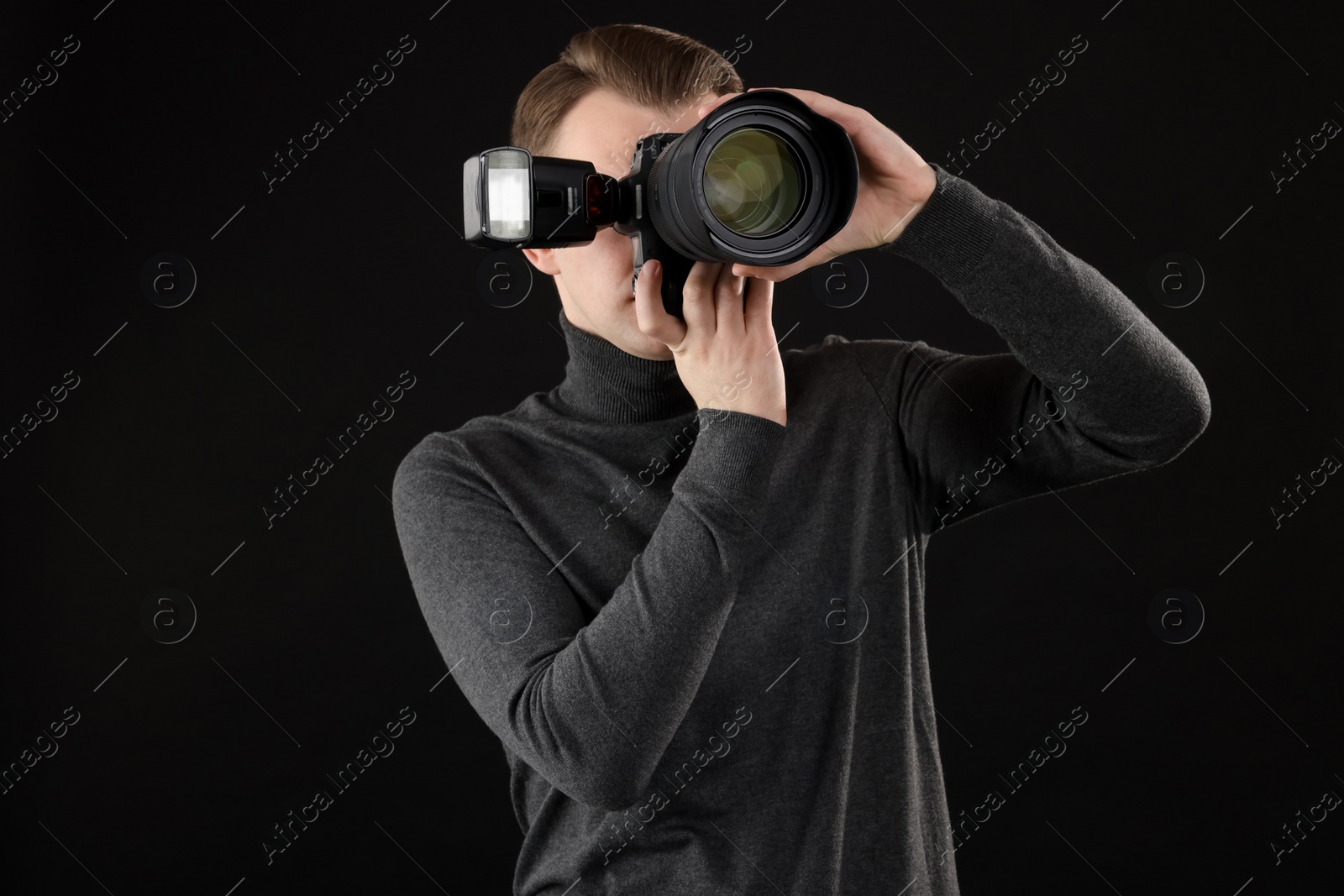 Photo of Professional photographer taking picture on black background