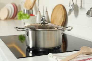 Photo of Shiny pot on electric stove in kitchen. Cooking utensil