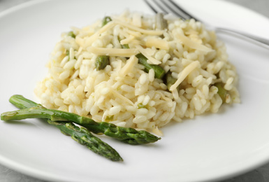 Delicious risotto with asparagus in plate, closeup