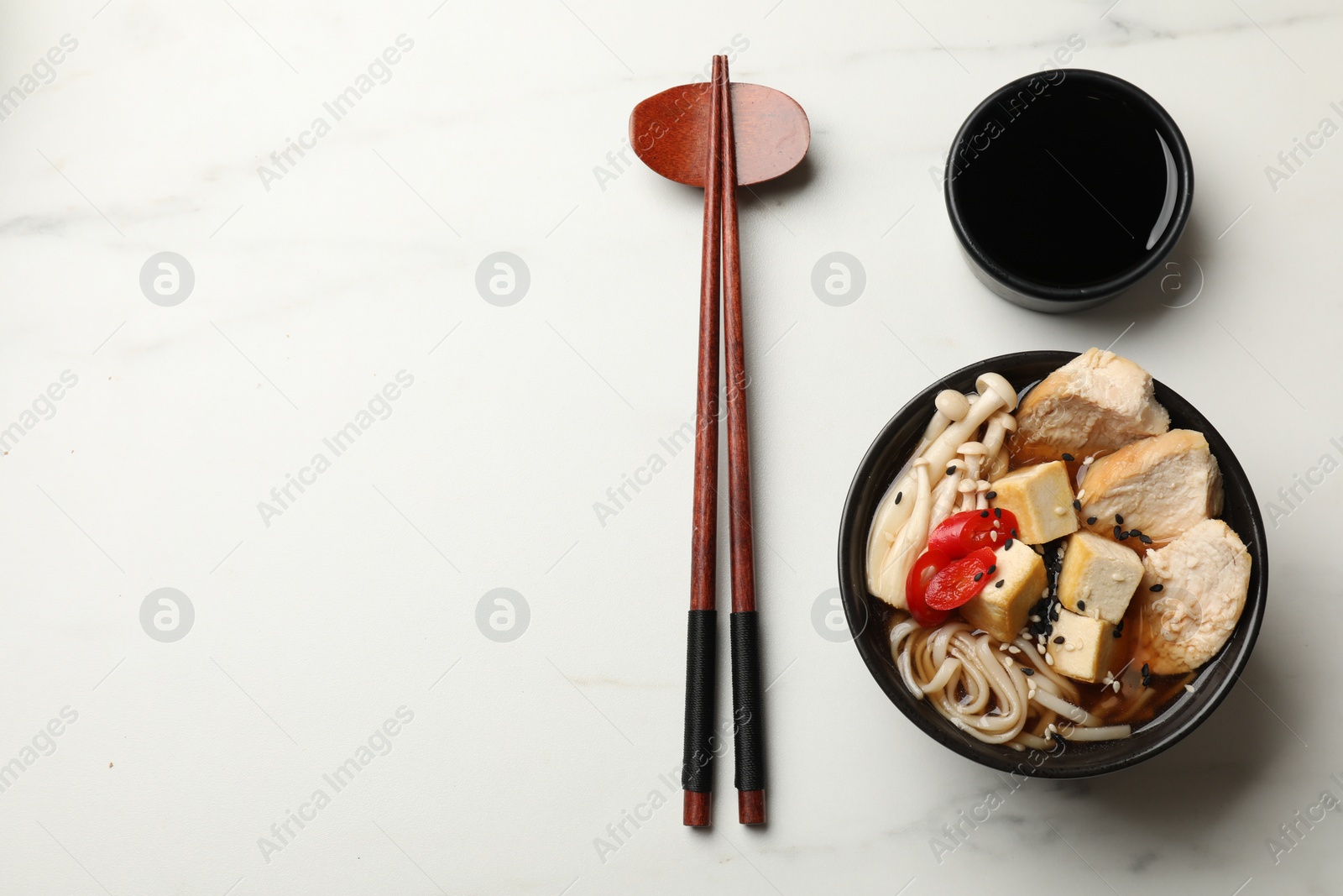 Photo of Delicious ramen served on white marble table, flat lay with space for text. Noodle soup