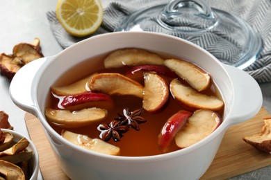 Delicious compote with dried apple slices and anise in pot on table, closeup