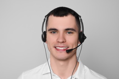 Photo of Hotline operator with headset on light grey background