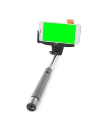 Image of Selfie stick and smartphone with green screen on white background. Mockup for design