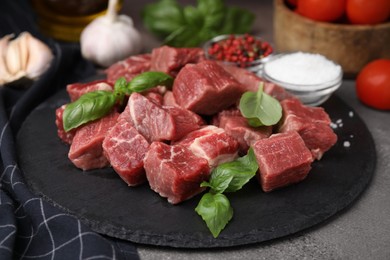 Photo of Cut fresh beef meat with basil and spices on brown table, closeup