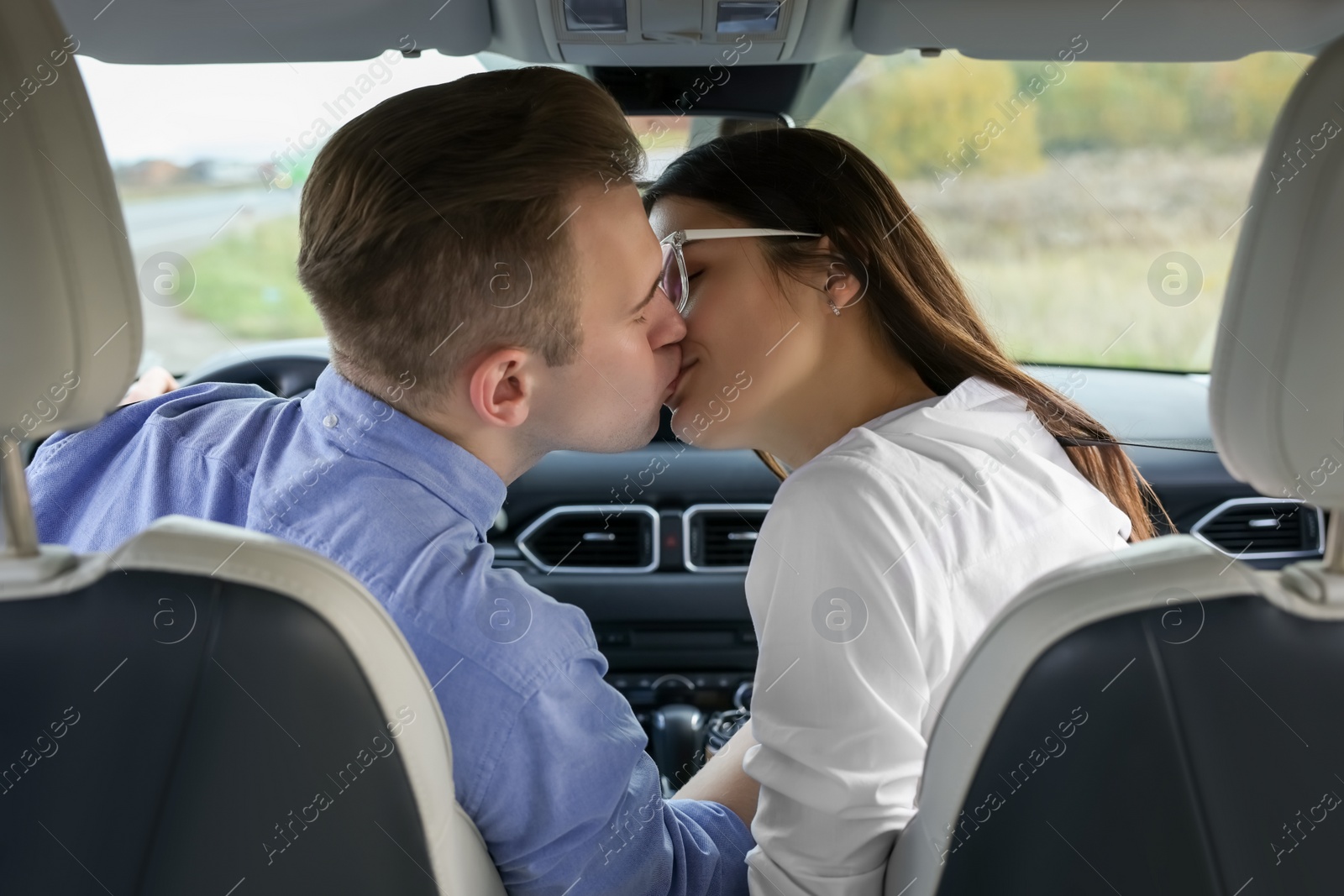 Photo of Happy young couple kissing in modern car