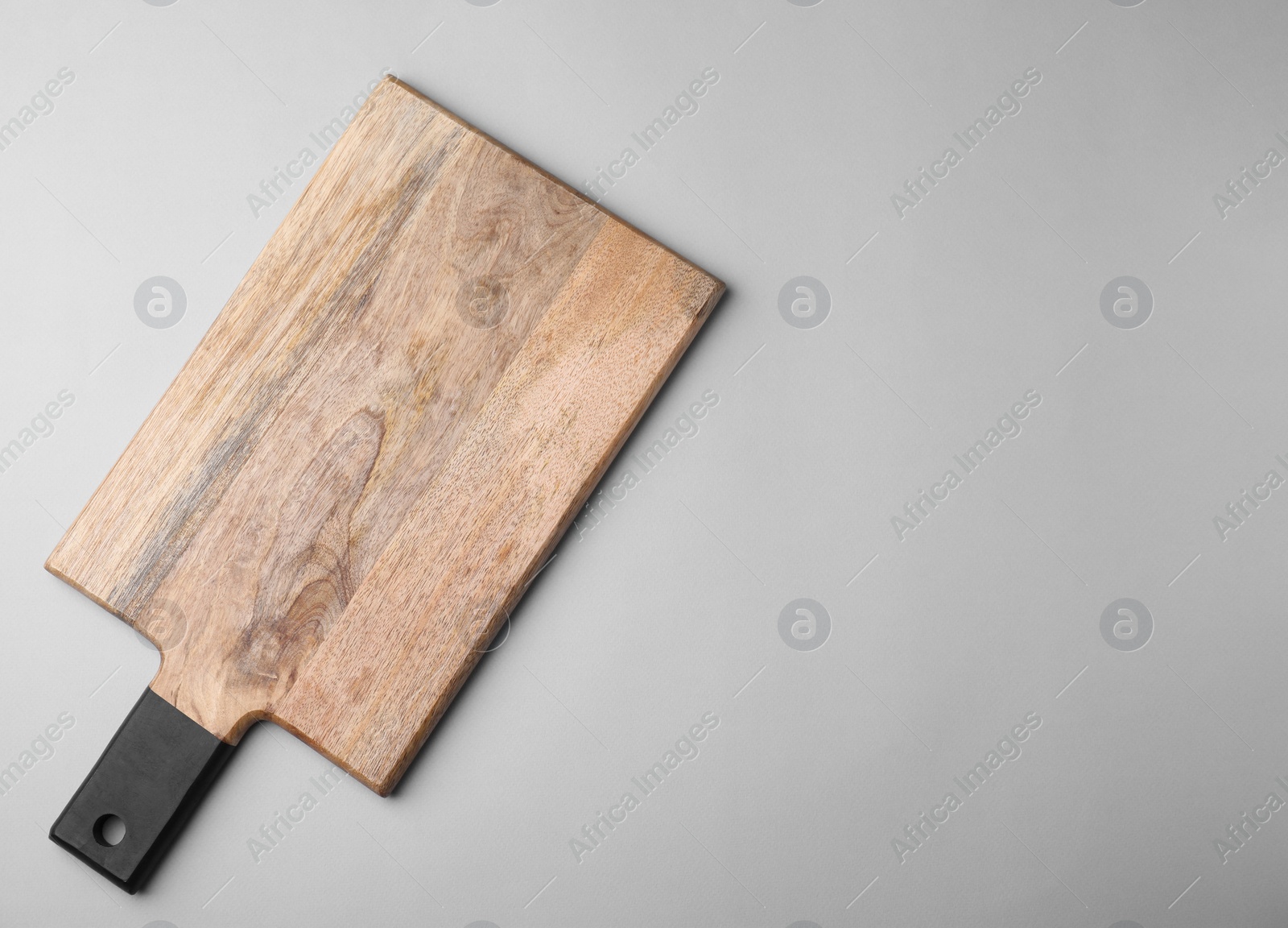 Photo of One wooden board on light grey background, top view. Space for text