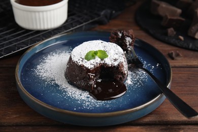 Photo of Delicious fresh fondant with hot chocolate and mint on wooden table