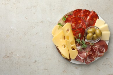 Photo of Serving board with delicious cured ham, cheese, sausage and olives on light table, top view. Space for text