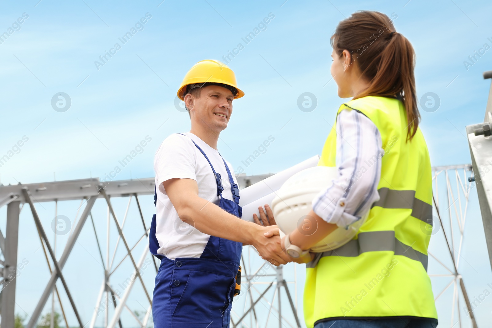 Photo of Professional engineers working on installation of electrical substation outdoors