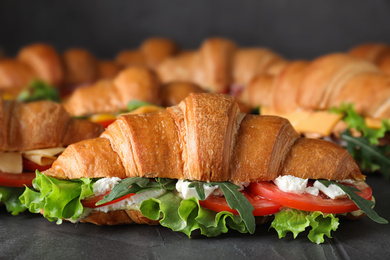 Photo of Tasty croissant sandwiches on grey table, closeup