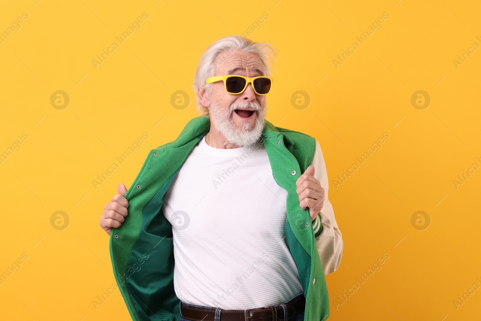 Photo of Portrait of grandpa with stylish sunglasses on yellow background