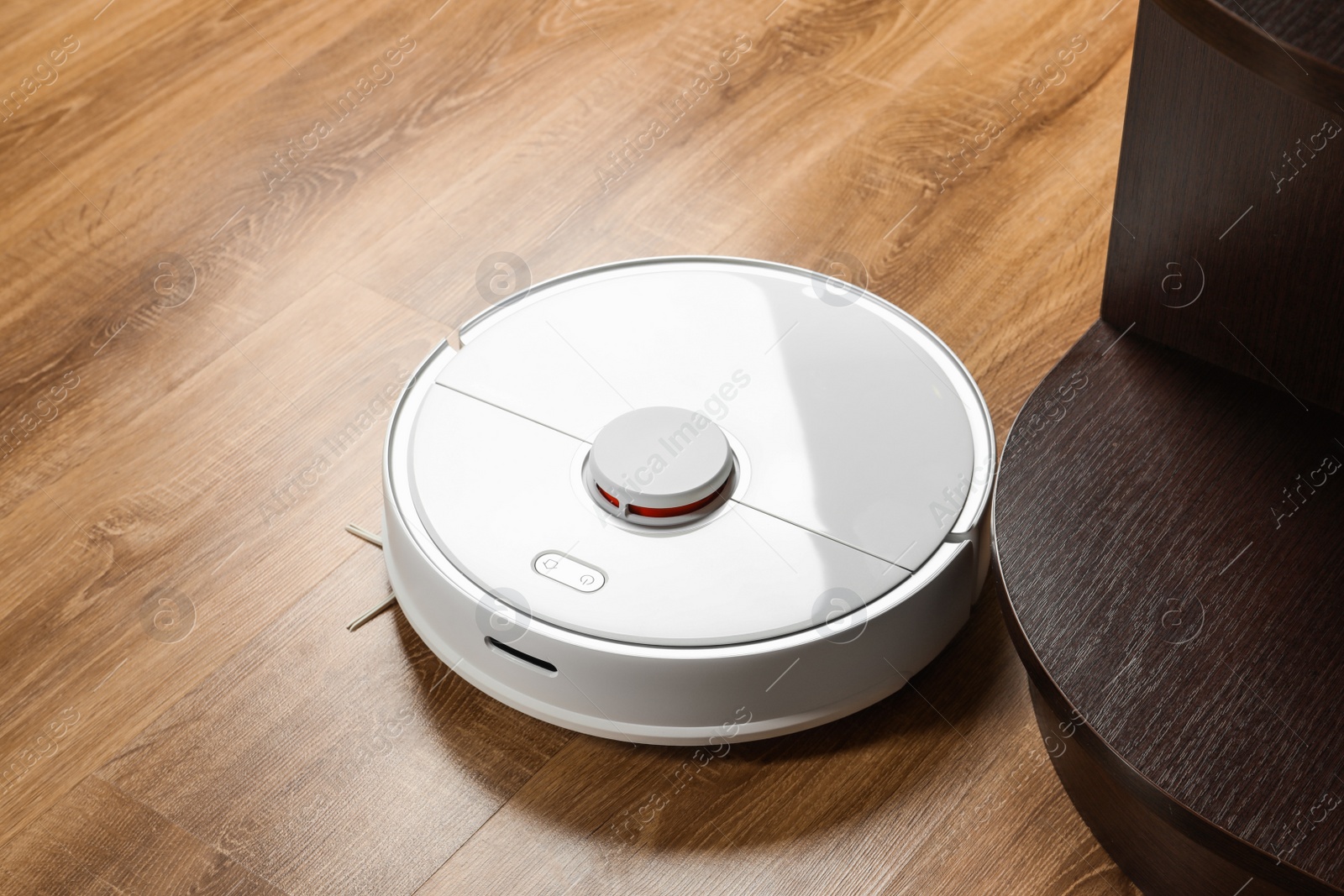 Photo of Robotic vacuum cleaner on wooden floor indoors