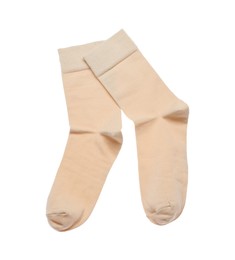 Photo of Beige socks on white background, top view