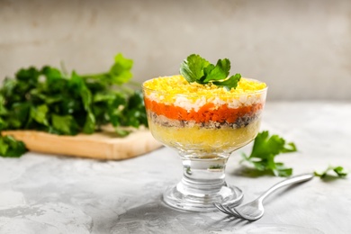 Traditional russian salad Mimosa served on light grey table