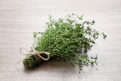 Photo of Bunch of aromatic thyme on wooden table