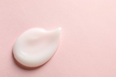 Photo of Sample of face cream on pink background, top view. Space for text