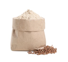 Photo of Paper bag with buckwheat flour and grains isolated on white