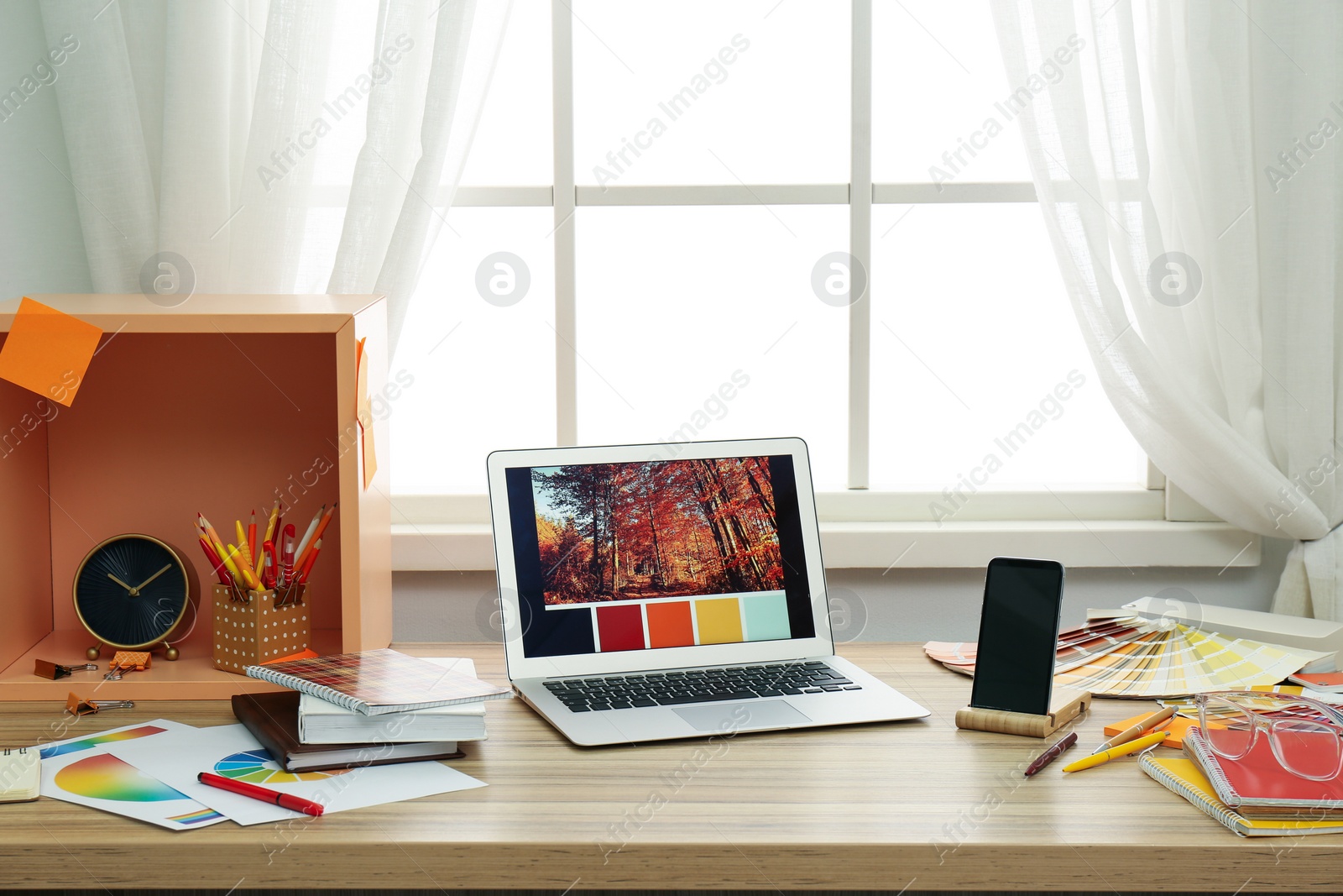 Photo of Designer's workplace with modern laptop and color palettes 