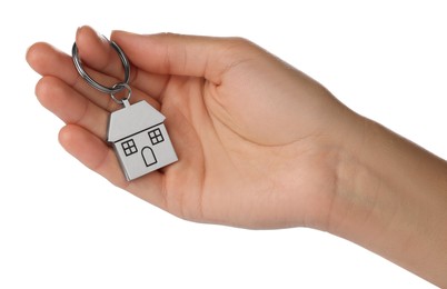 Photo of Woman holding metallic keychain in shape of house on white background, closeup