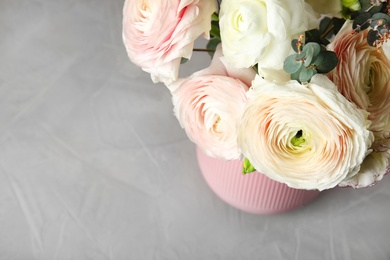 Photo of Beautiful spring ranunculus flowers in vase on table, view from above. Space for text