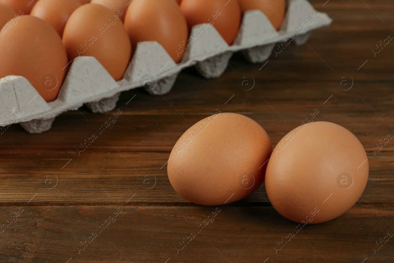 Photo of Raw brown chicken eggs on wooden table