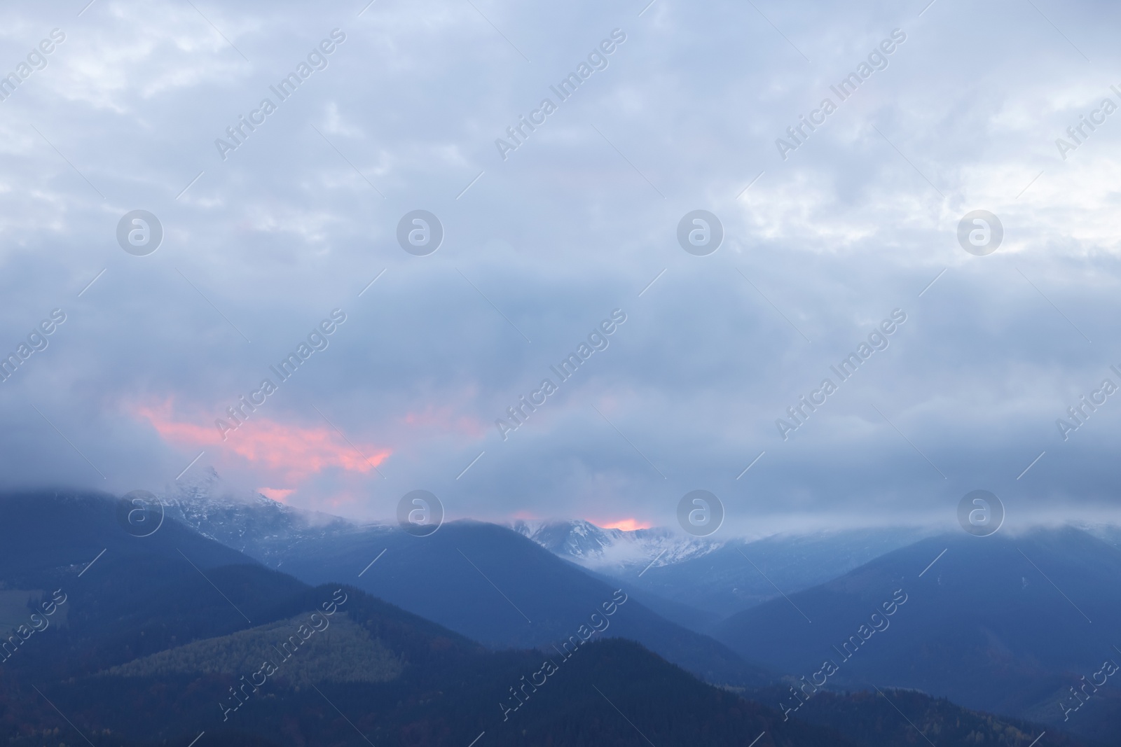 Photo of Beautiful view of mountains covered with fog and cloudy sky during sunrise