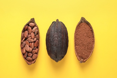 Photo of Cocoa beans, powder and pods on yellow background, flat lay