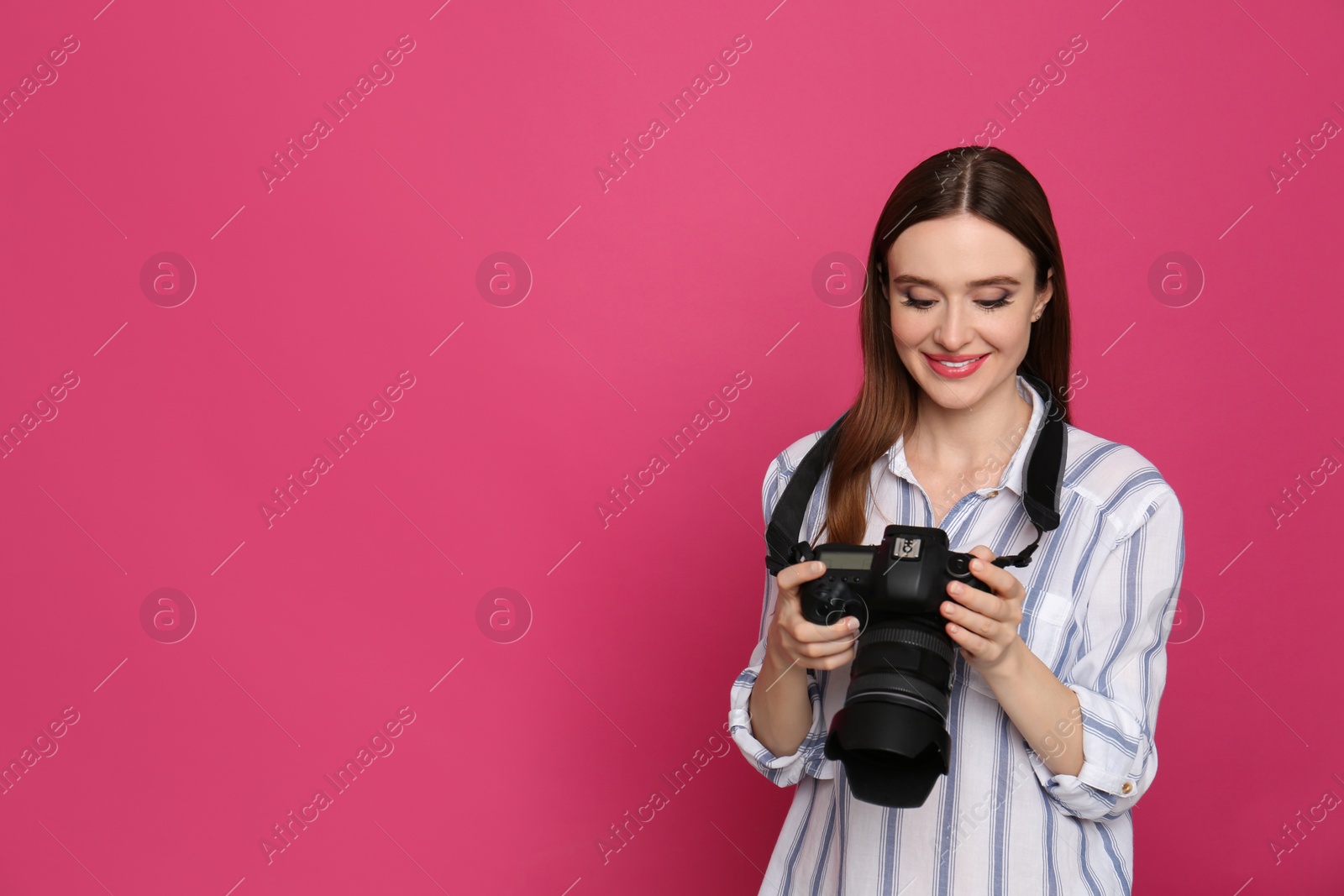 Photo of Professional photographer with modern camera on pink background. Space for text