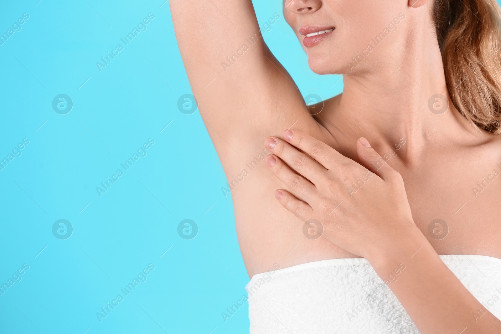 Photo of Young woman showing armpit on color background, space for text. Using deodorant