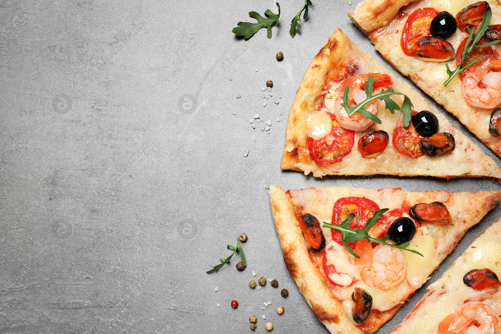 Photo of Tasty pizza with seafood and ingredients on grey table, flat lay. Space for text