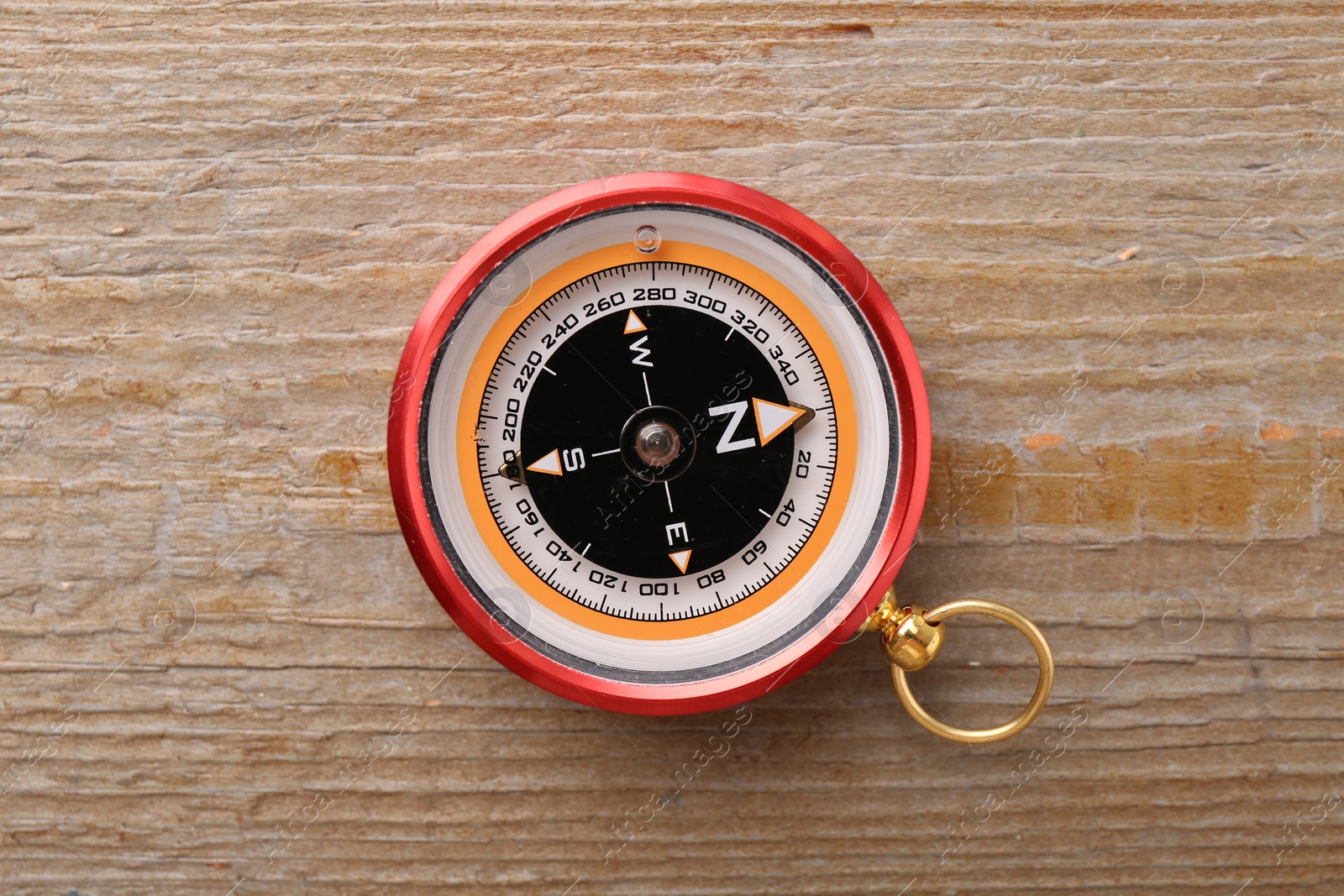 Photo of One compass on wooden table, top view