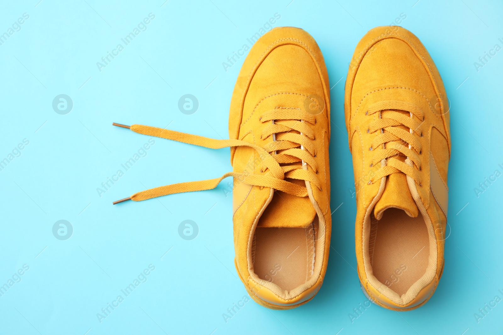 Photo of Pair of stylish shoes on light blue background, top view. Space for text