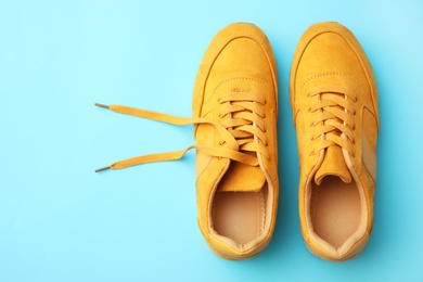 Pair of stylish shoes on light blue background, top view. Space for text