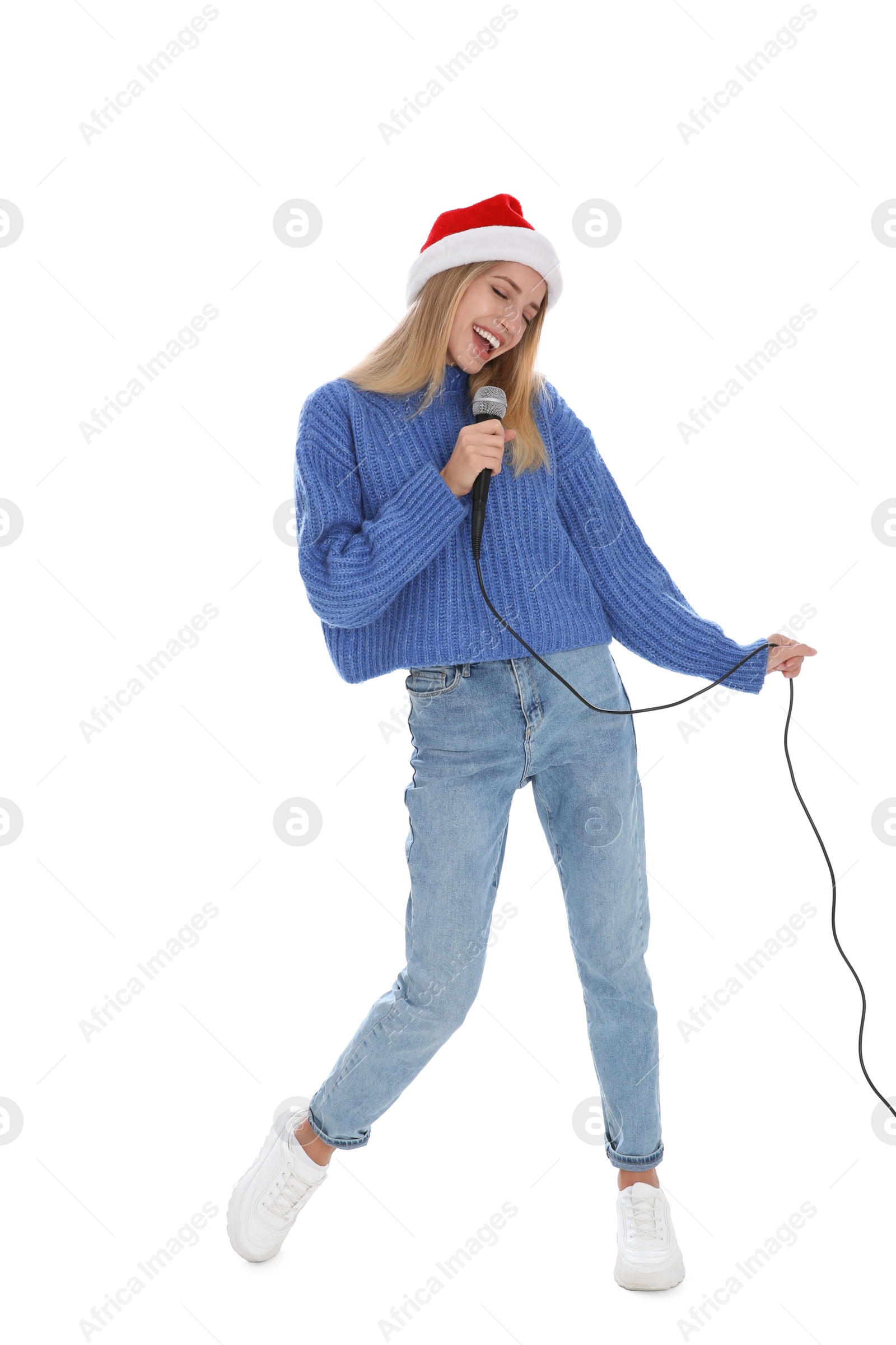 Photo of Happy woman in Santa Claus hat singing with microphone on white background. Christmas music